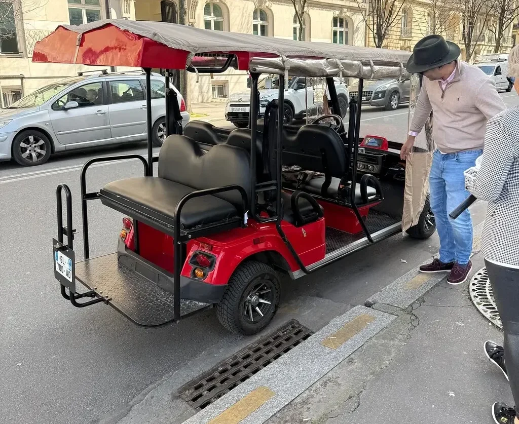 Private golf cart parked near a Parisian landmark during a sightseeing tour